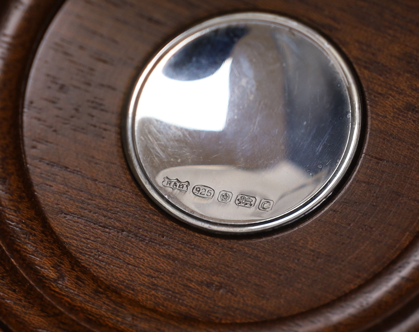 A pair of Elizabeth II silver mounted wine coasters, with turned wooden bases, Roberts & Dore, Sheffield, 2002, diameter 12.4cm, each individually boxed.